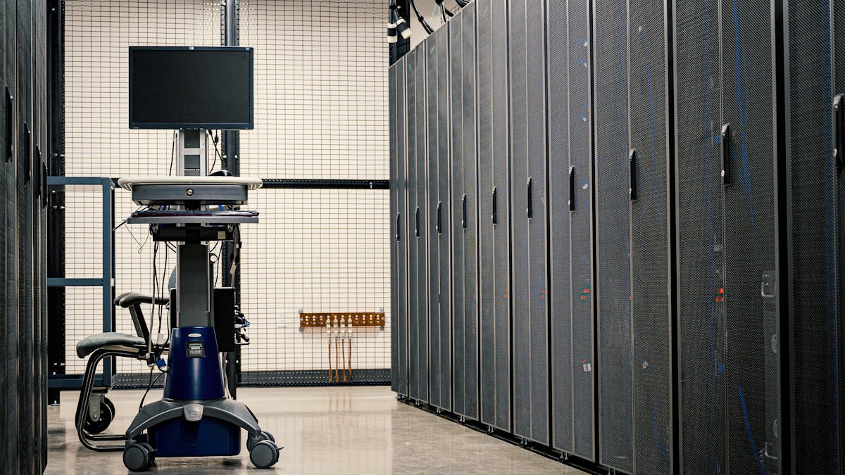 Dark server rack aisle with faint blue lights suggesting a data center under threat