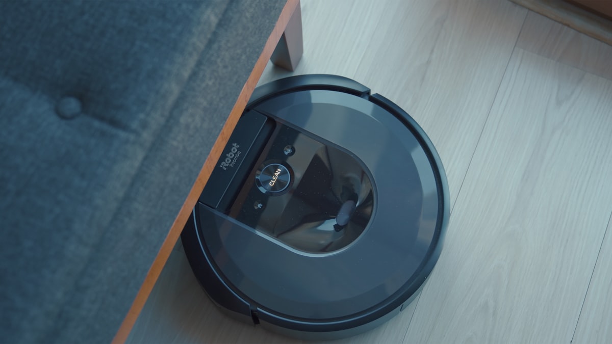 Robot vacuum cleaner on a floor next to furniture